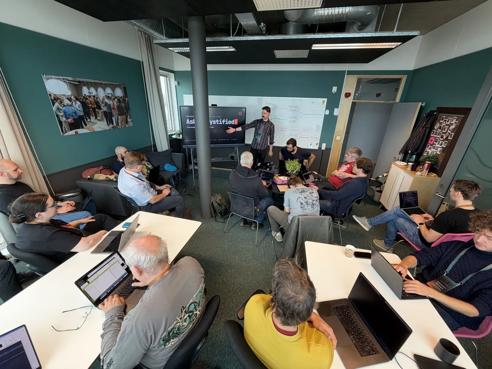 Conor presenting the Ash Demystified title slide to a room of attendees with laptops